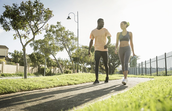 casal em parque aproveitando os benefícios da caminhada