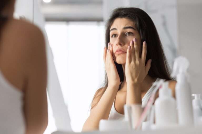 mulher examinando sinais de pele cansada