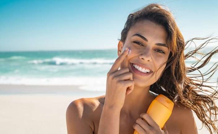 mulher com protetor e dicas de como manter o bronzeado por mais tempo