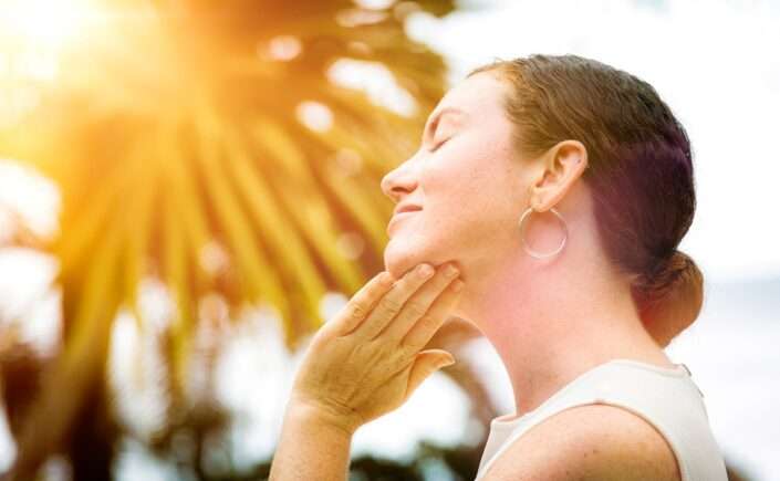 mulher aplicando protetor para prevenir manchas de pele no verão