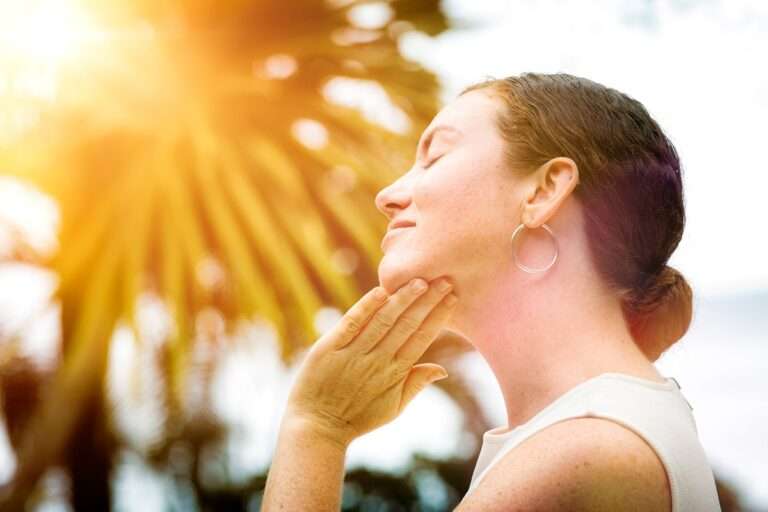 mulher aplicando protetor para prevenir manchas de pele no verão