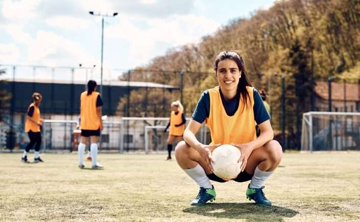 mulher praticando futebol feminino