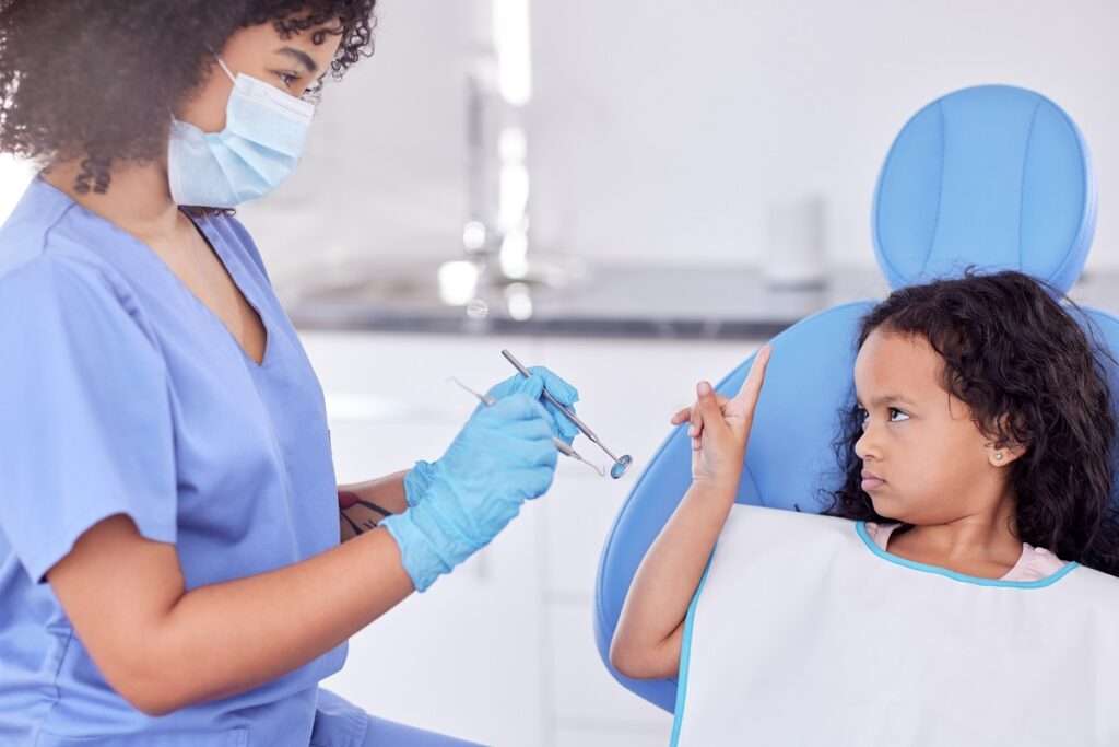 criança com medo de dentista no consultório com profissional